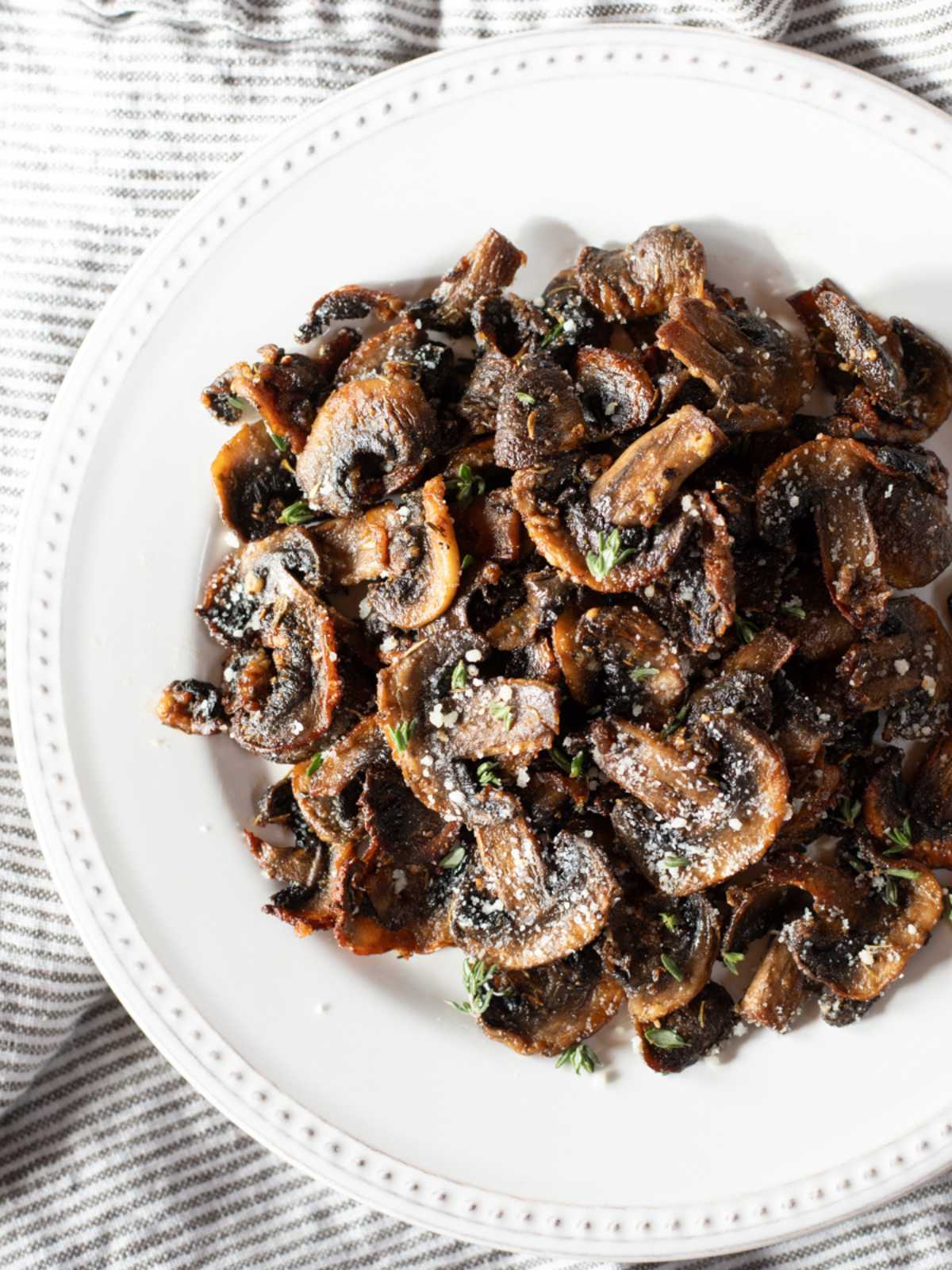 Cooked, sliced mushrooms in a white bowl.