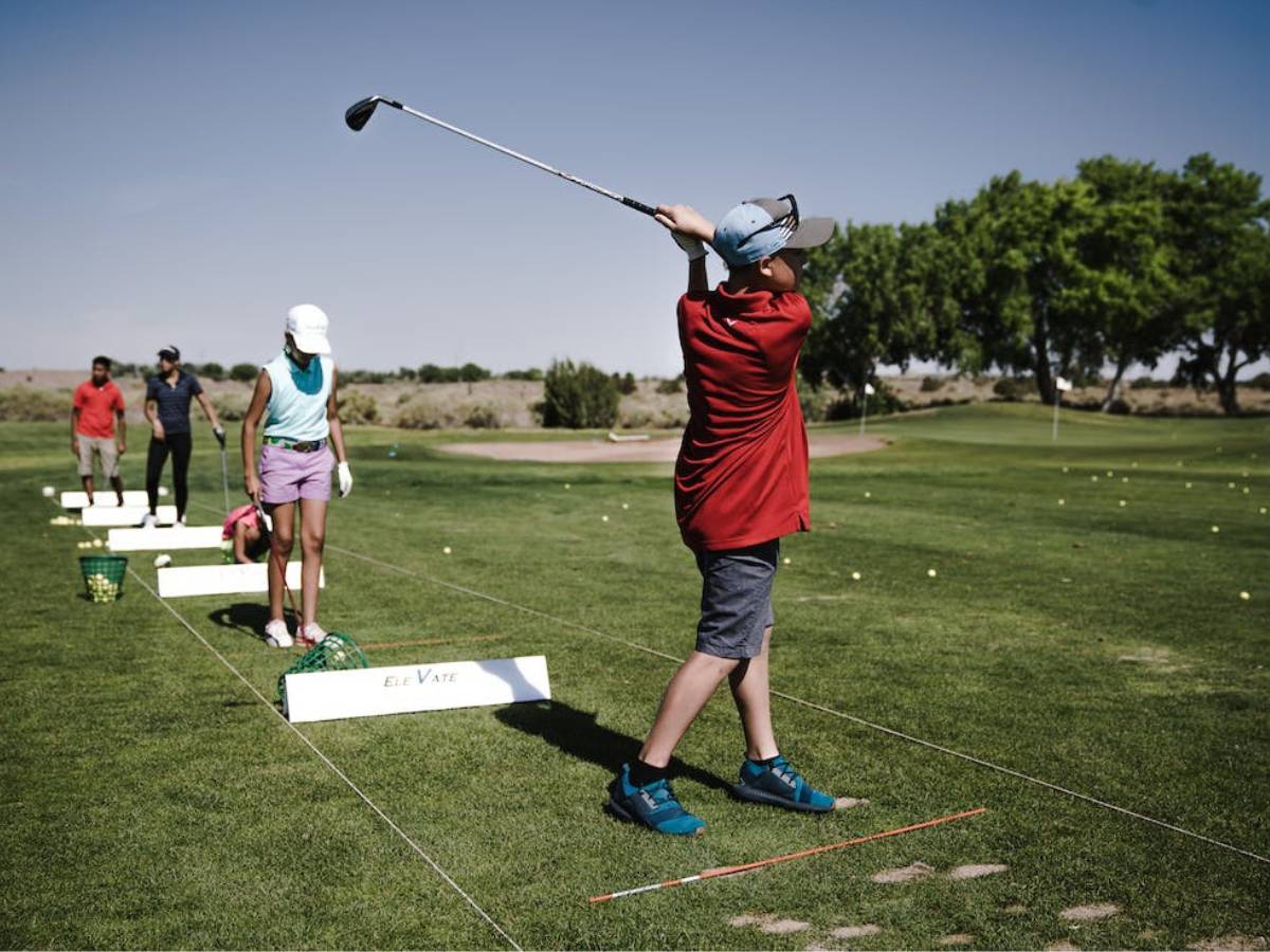 Person swinging golf club on field