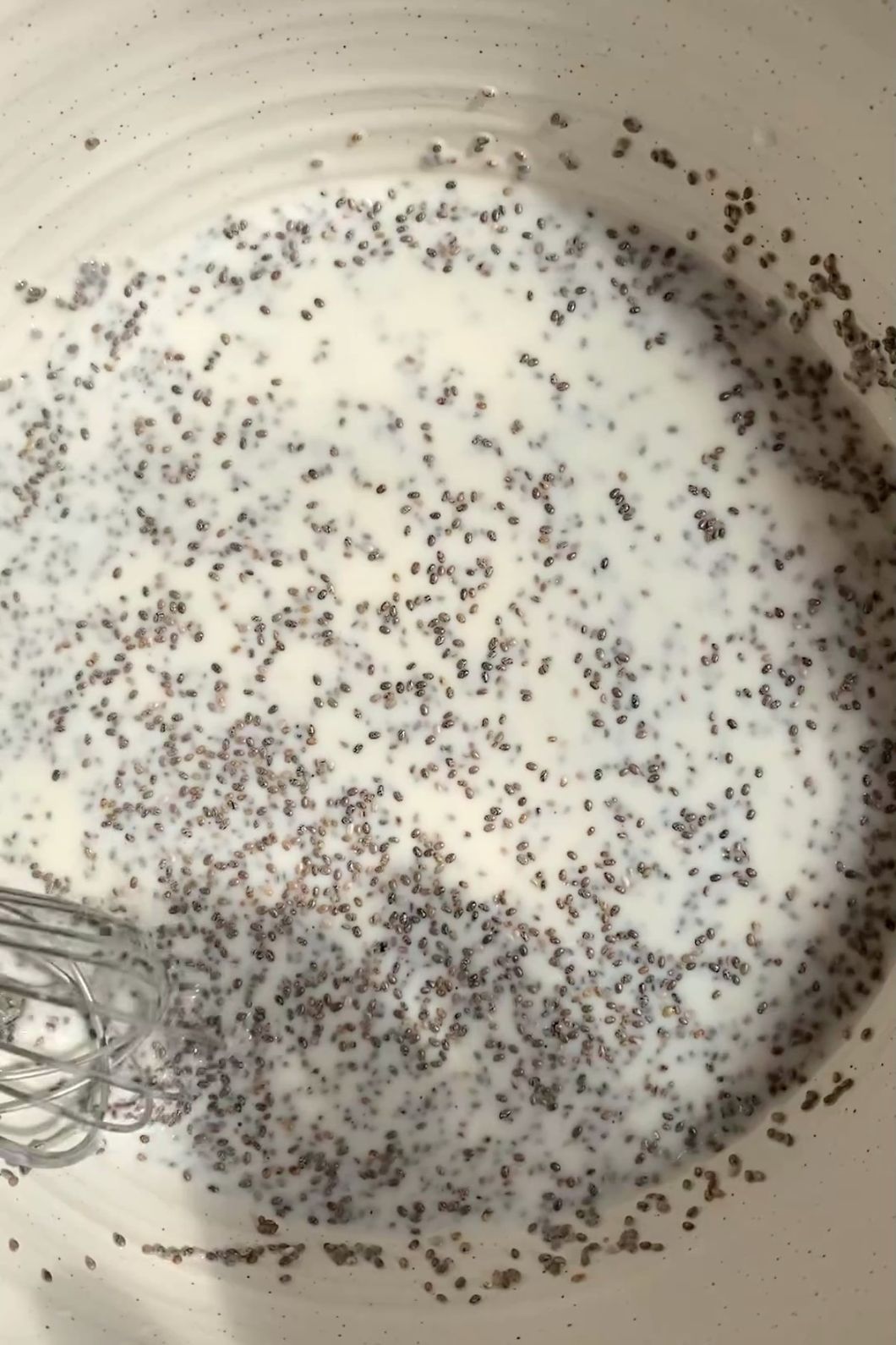 Mixed coconut milk, chia seeds, and maple syrup in a bowl.