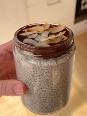 Coconut chia pudding with a chocolate topping and coconut flakes for garnish.