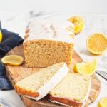 Vegan lemon pound cake with lemon slices on a cutting board.