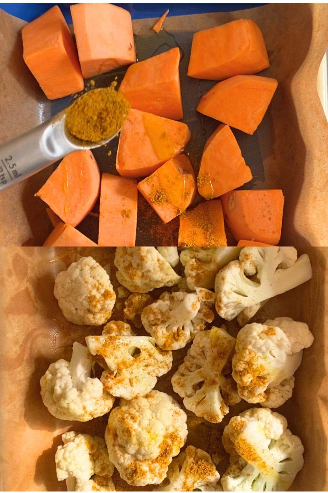 Chopped sweet potatoes and cauliflower in a baking dish, sprinkled with curry and drizzled with oil, ready for roasting.