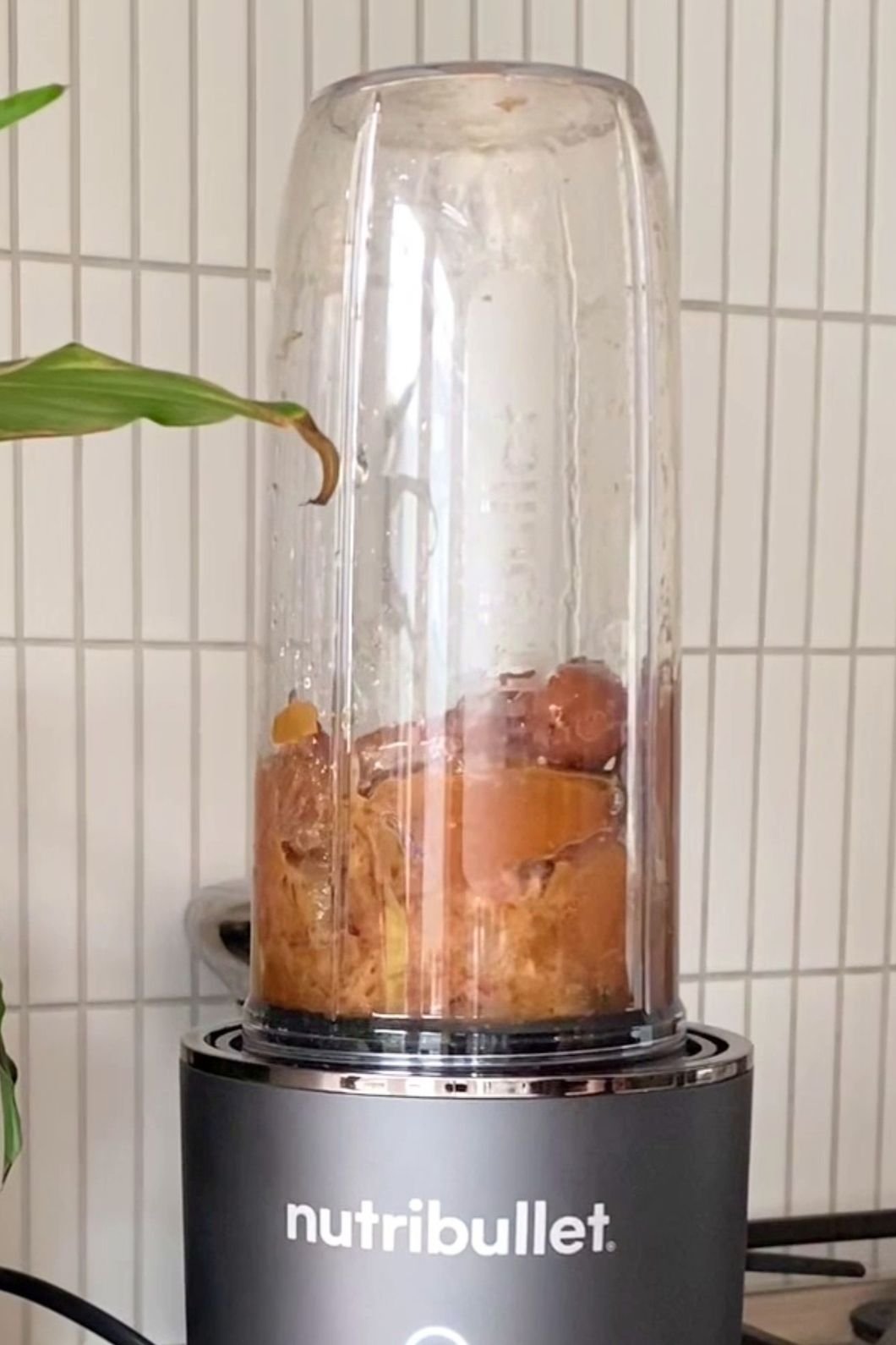 Soaked dates blending in a NutriBullet to form a thick, smooth paste.