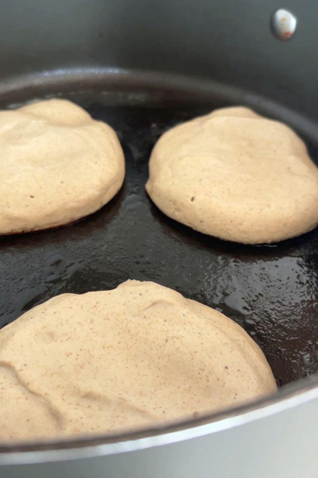 Pancake batter cooking in pan.