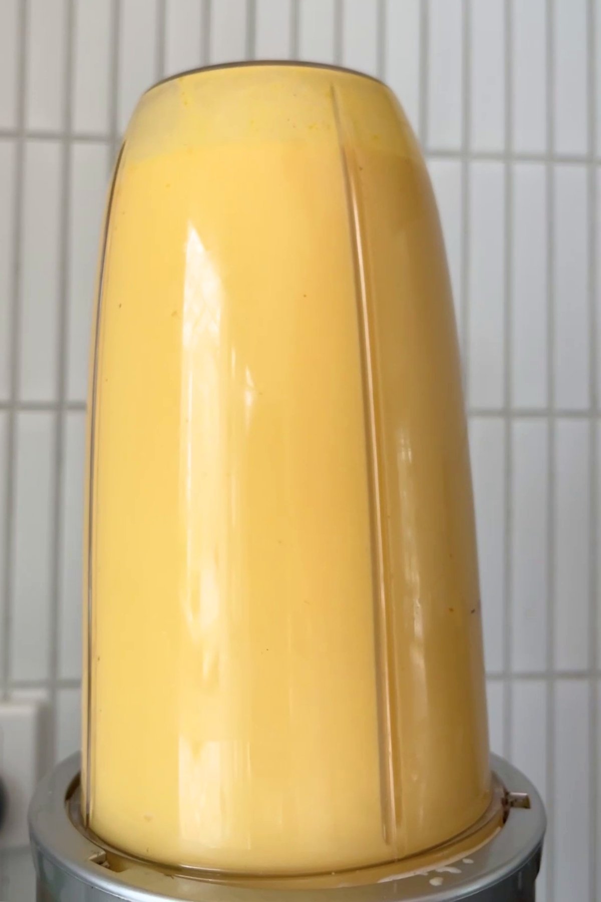 Pumpkin sauce blending in a closed Nutribullet blender, creating a smooth, pale orange mixture.