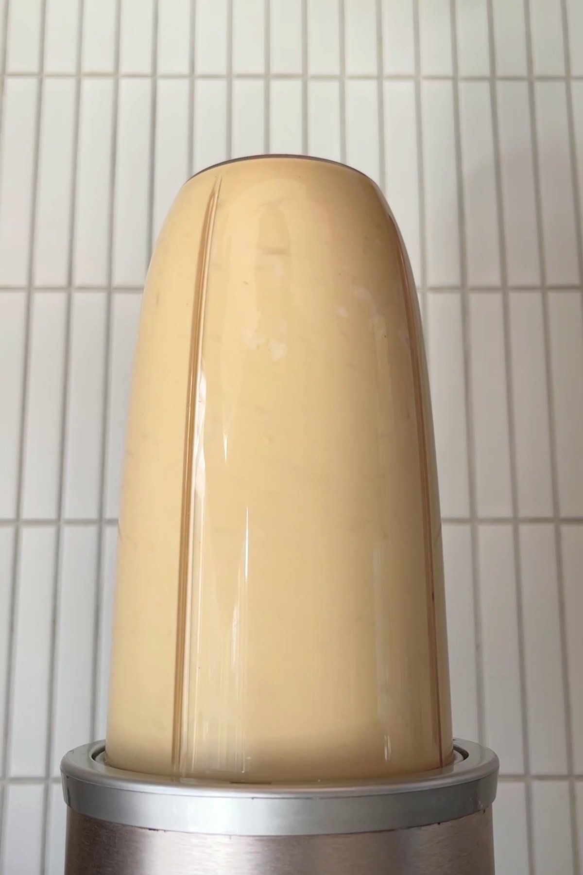 Blended creamy yellow mixture in a bullet blender, forming a smooth, uniform consistency.