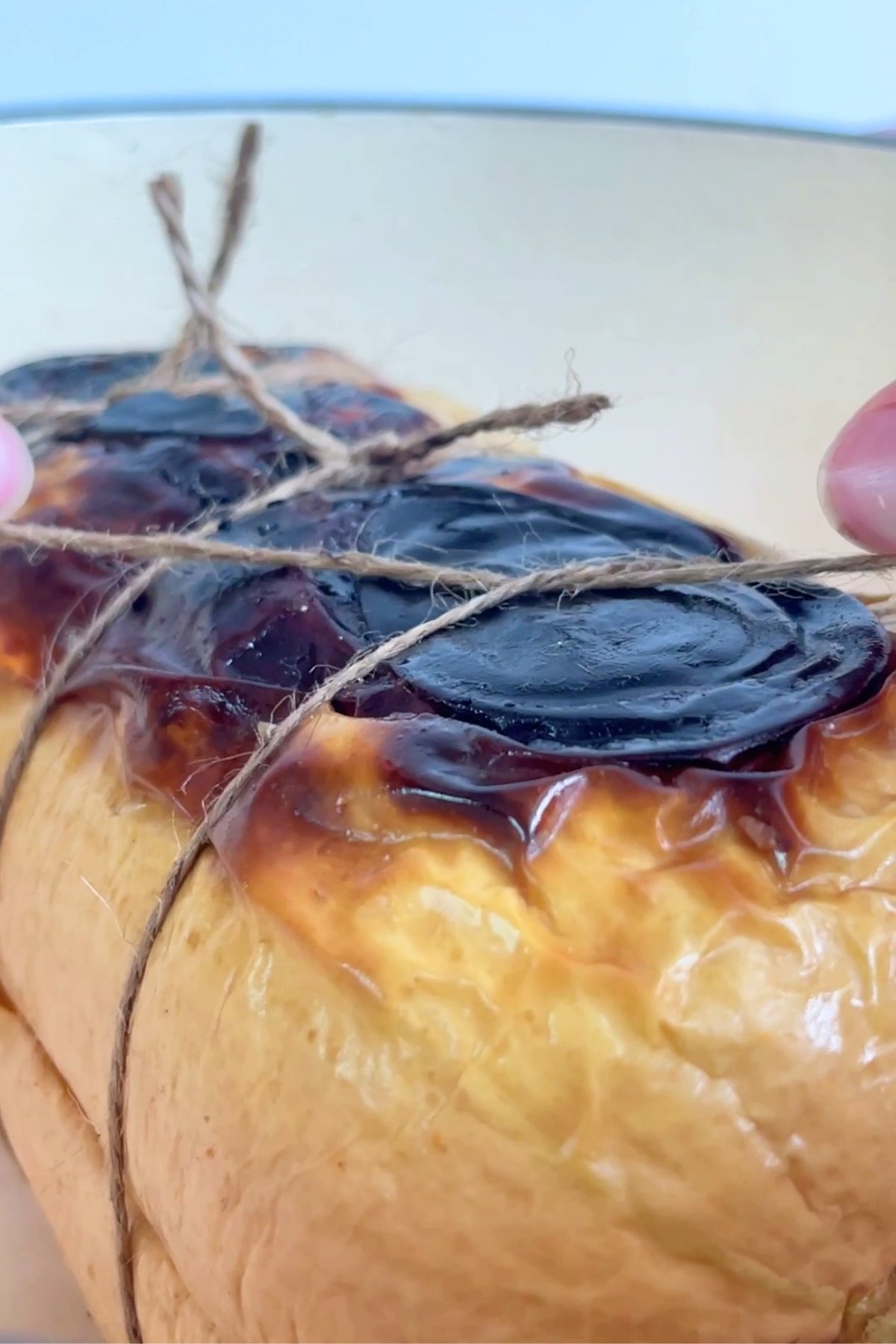 Roasted stuffed pumpkin tied with kitchen twine, showing charred tops and glossy, caramelized edges.