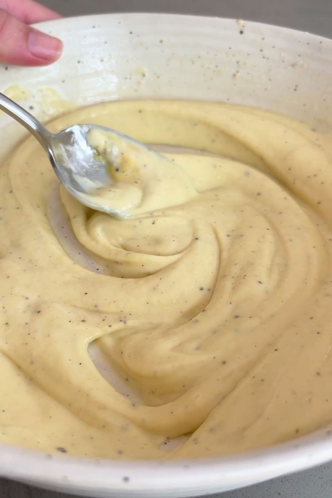 Stirring creamy vegan mayo sauce.