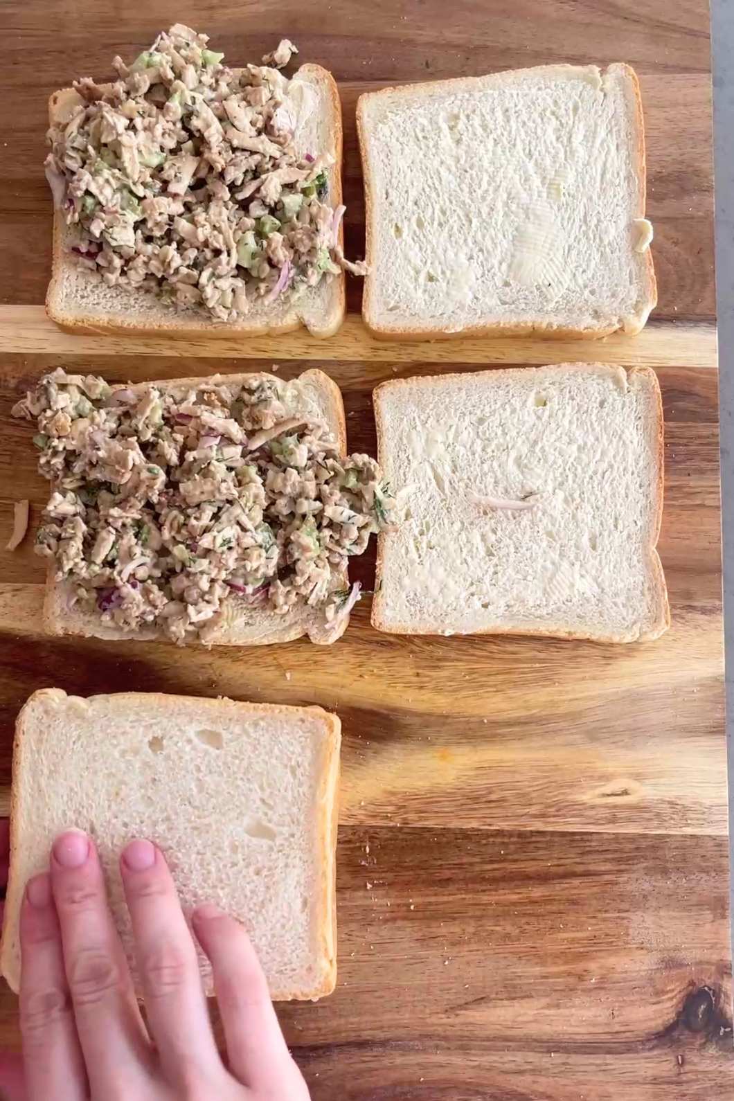 Adding top bread to filled sandwich.