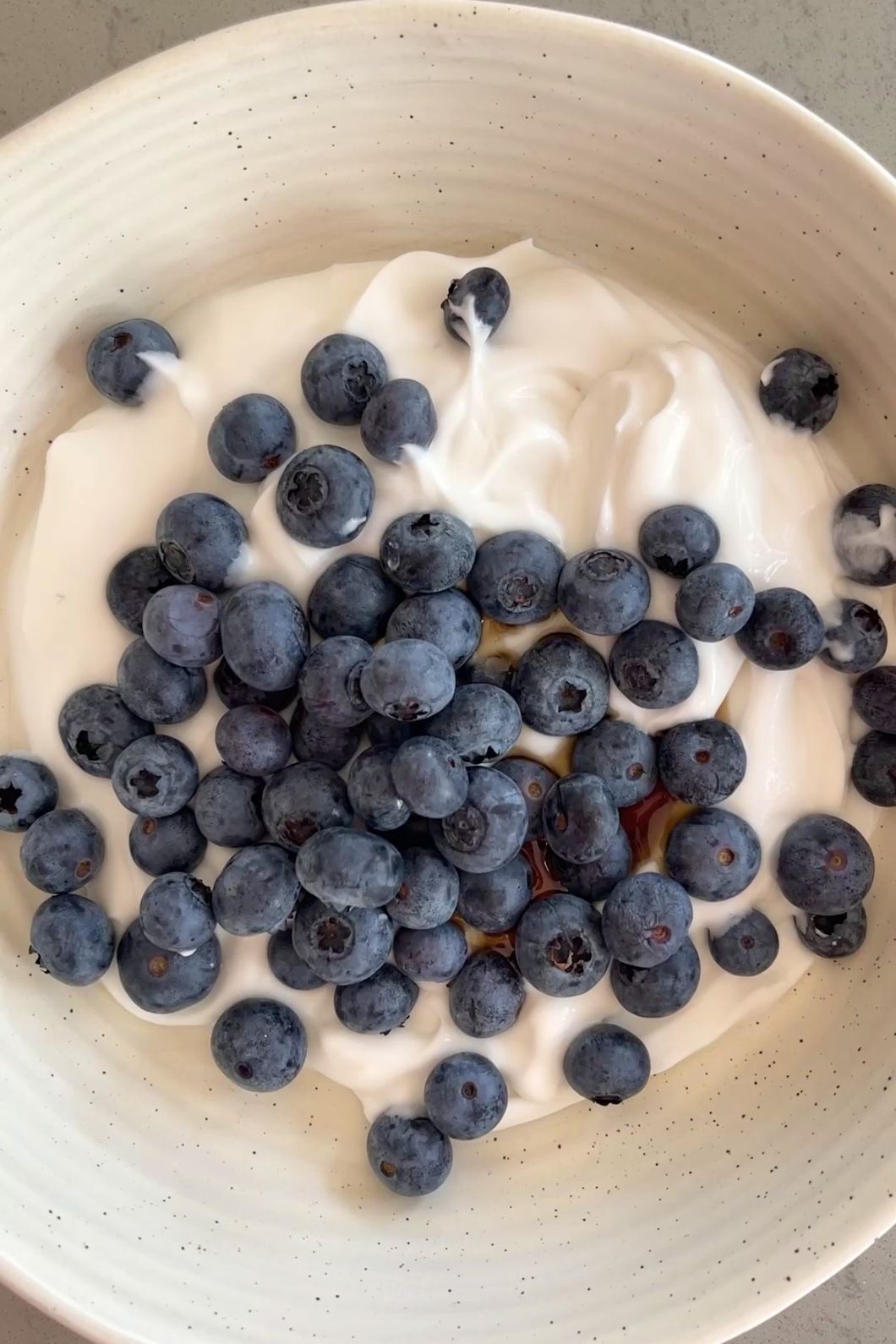 Blueberries and yogurt with drizzle of maple syrup.