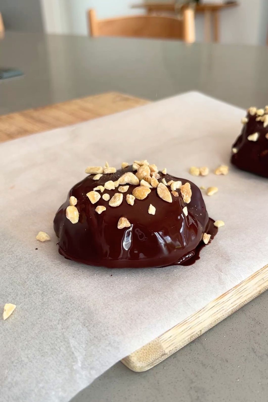 Dark chocolate-coated yogurt blueberry bite with peanut toppings.