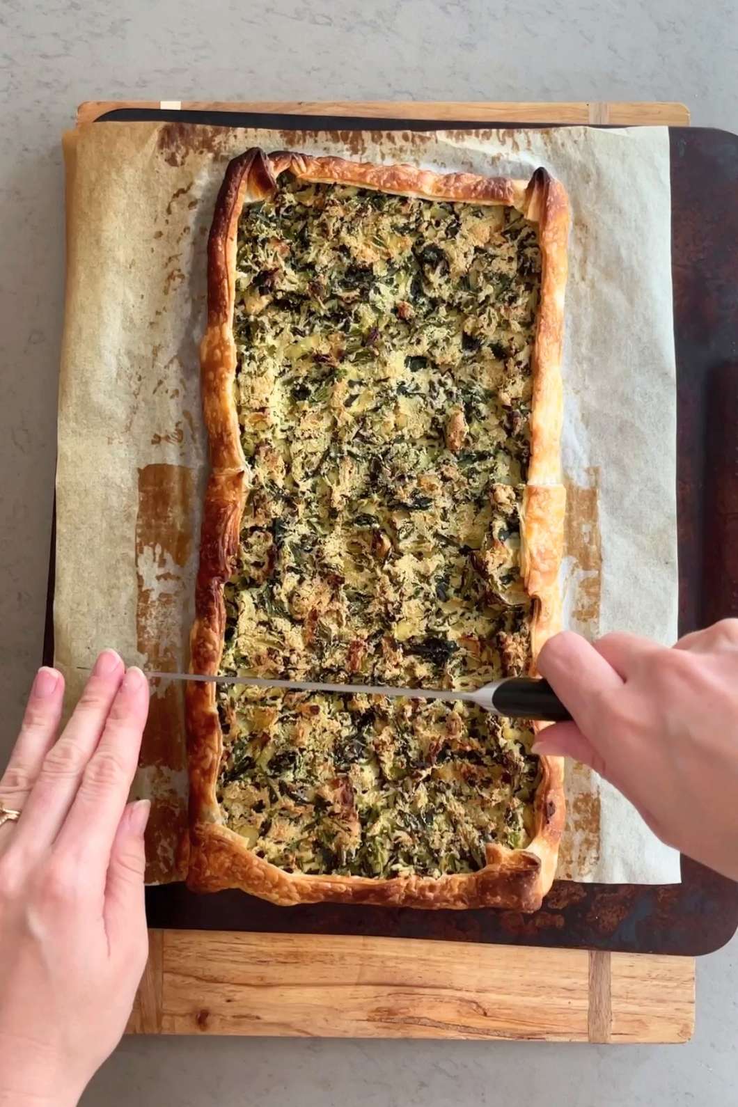 Slicing freshly baked spinach galette.