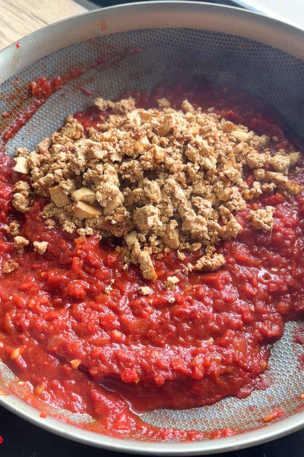 Sautรฉed bell peppers coated in red tomato sauce with crispy crumpled tofu.
