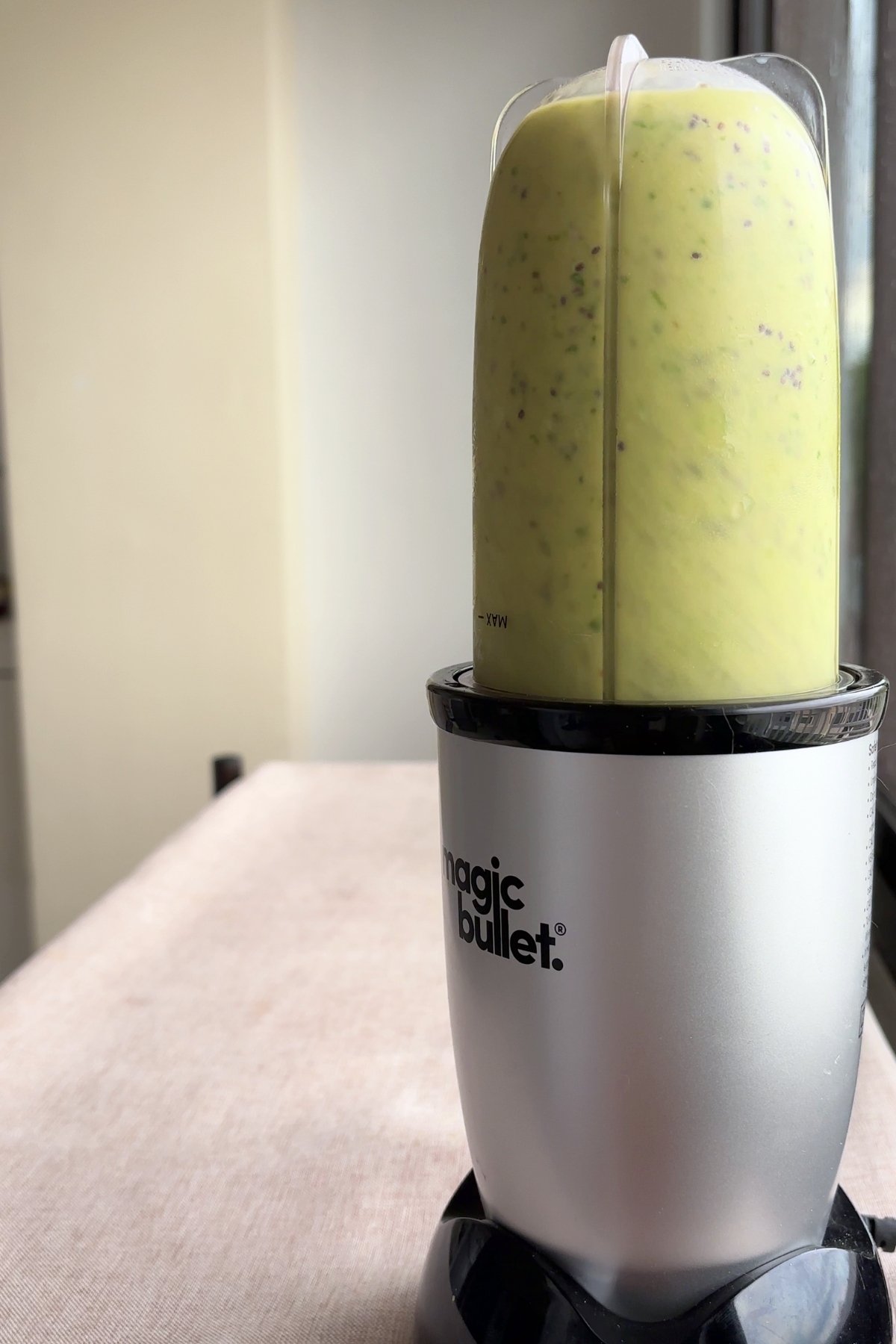Green smoothie swirling inside a blender cup during blending.