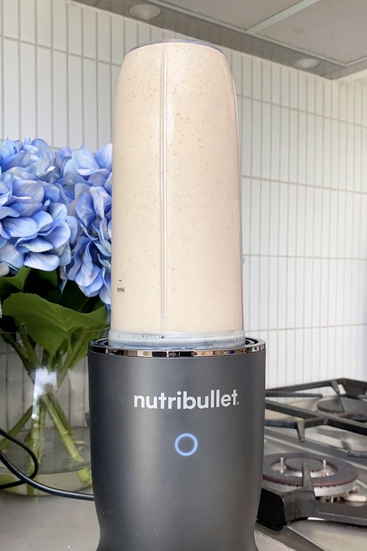 Blender cup filled with smooth beige mixture inverted on nutribullet base.