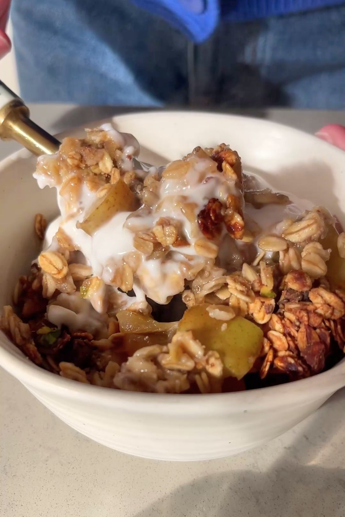 Creamy yogurt over warm oat-and-fruit crumble in a white bowl.