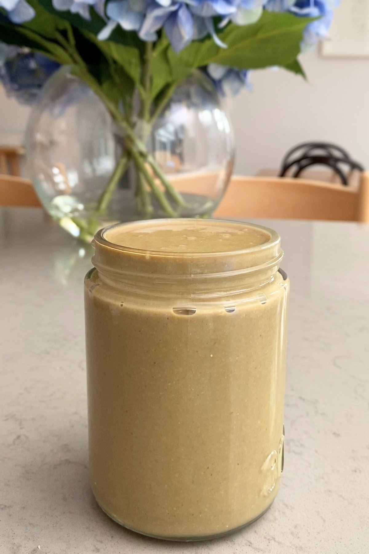 A glass jar filled to the brim with homemade sunflower seed butter.