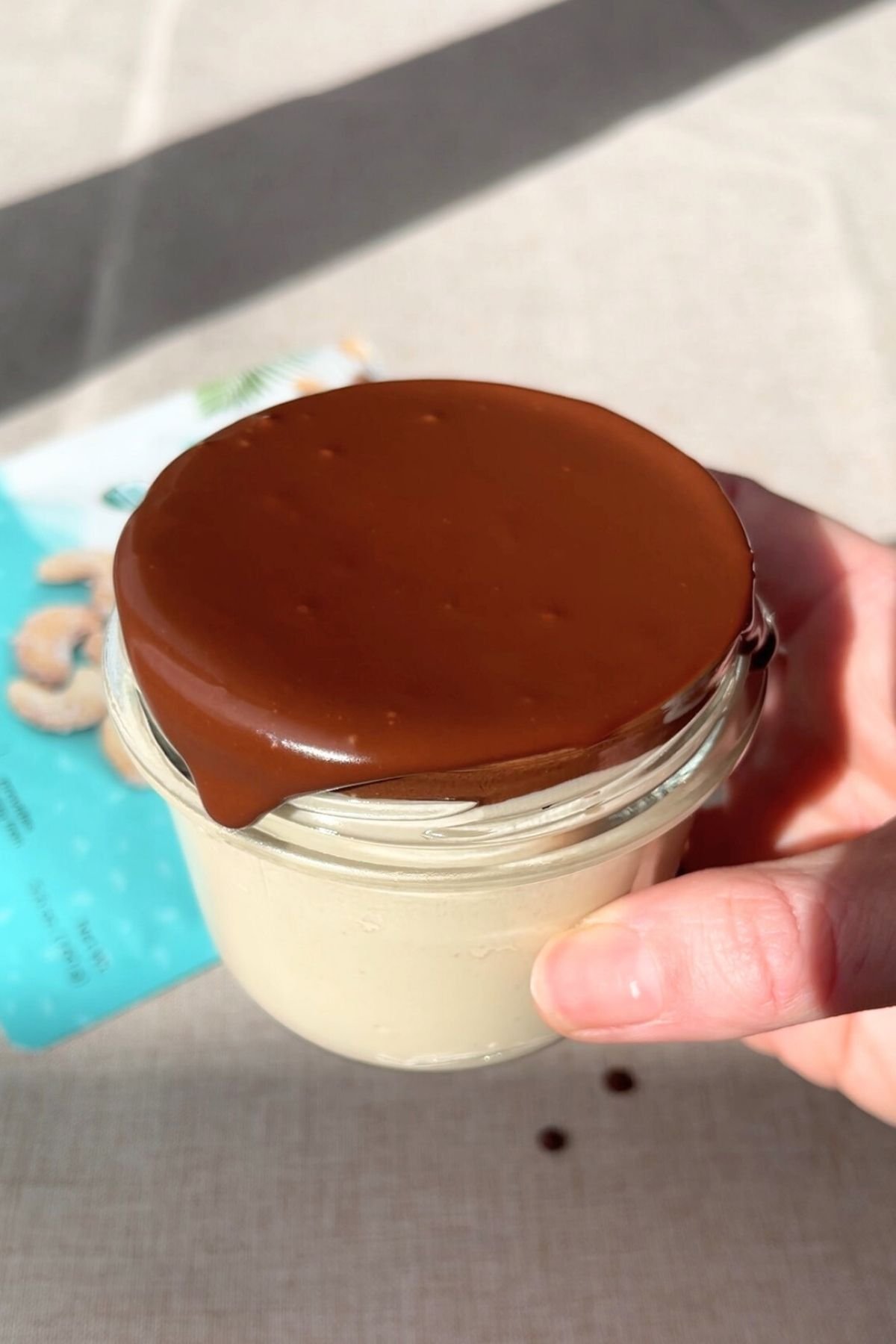 A jar of mousse topped with a firm chocolate ganache layer.
