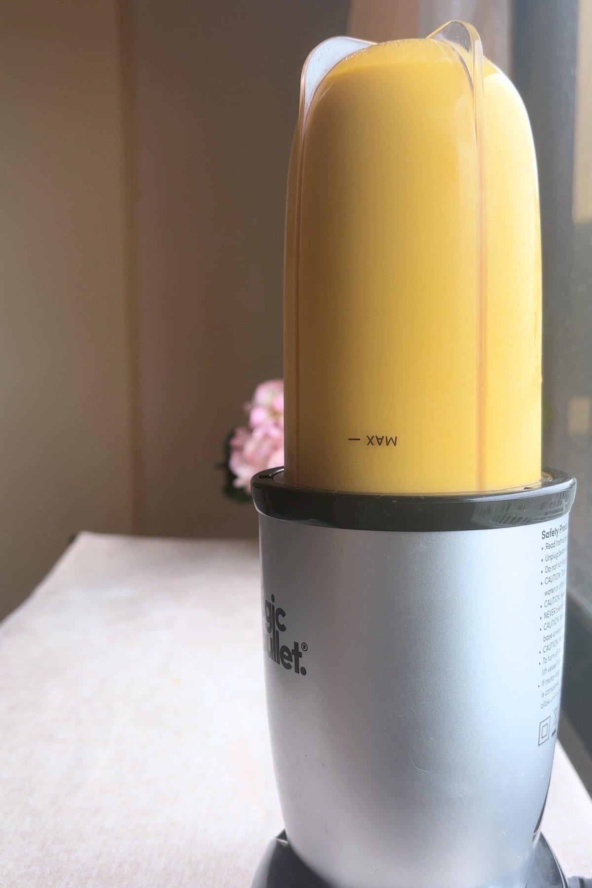 Smooth blended mango mixture filling the blender cup.