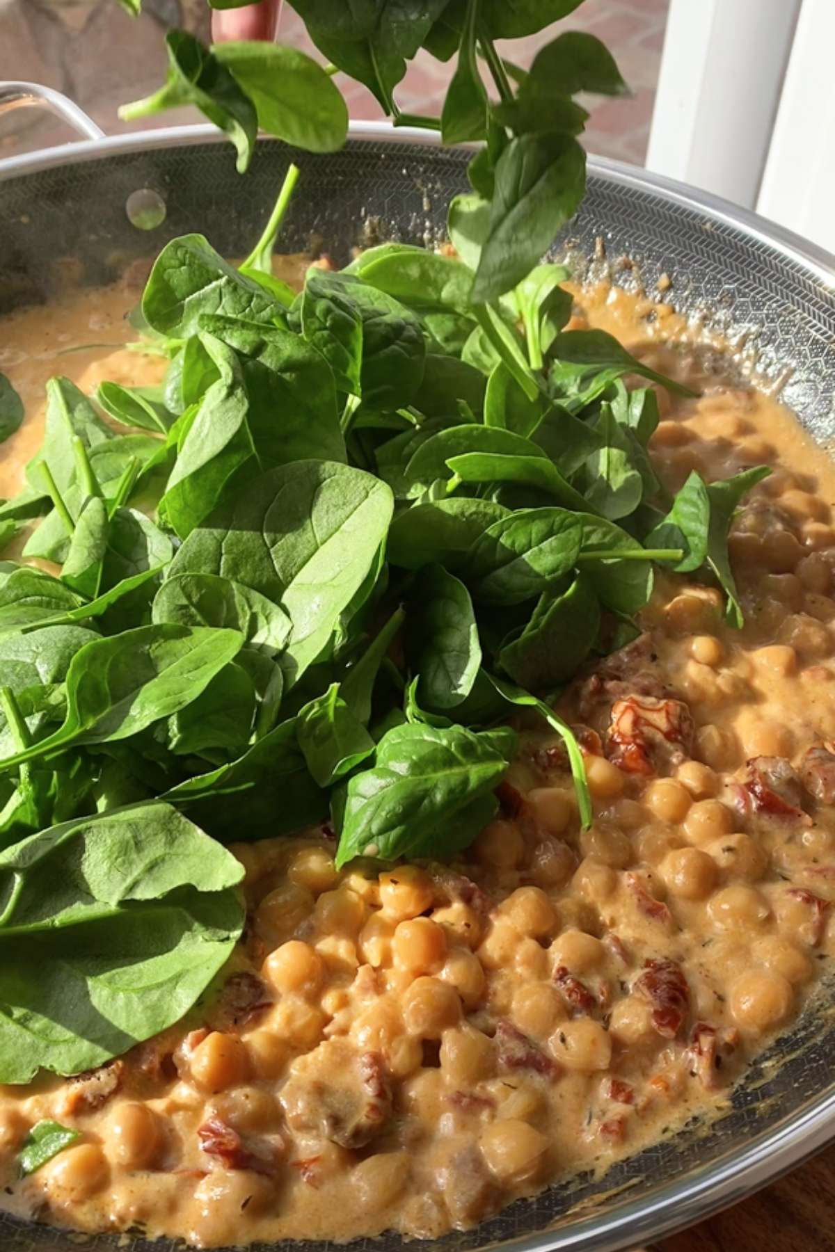 Fresh spinach leaves added to the creamy chickpea mixture.