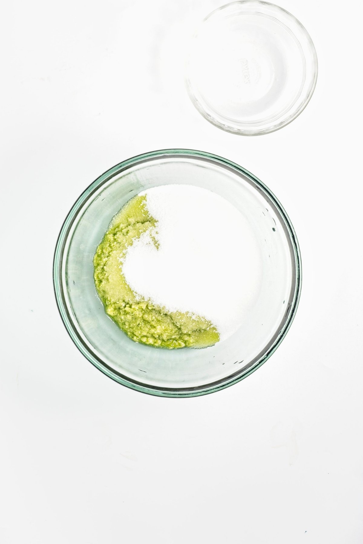 Zucchini puree in a bowl topped with granulated sugar.