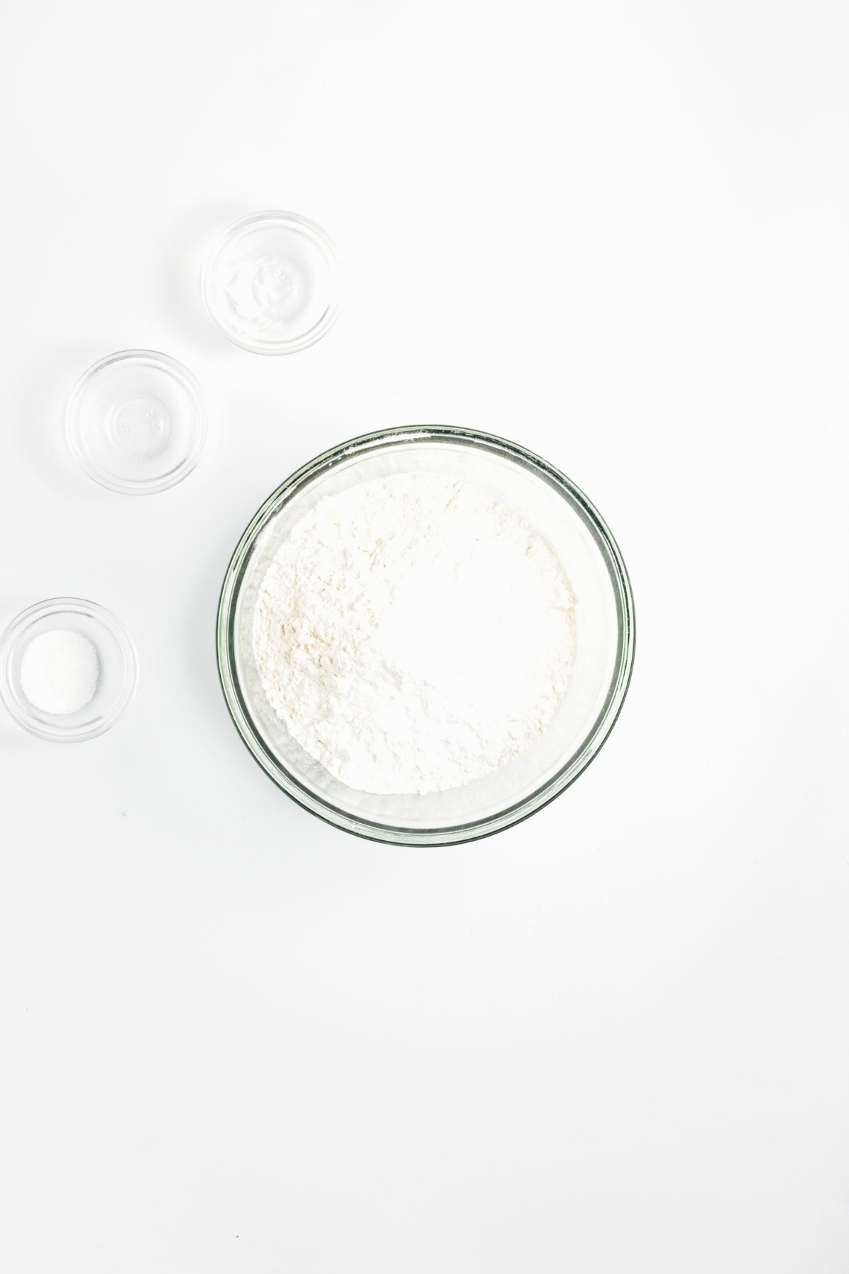 Flour, baking powder, baking soda, and salt combined in a glass mixing bowl.