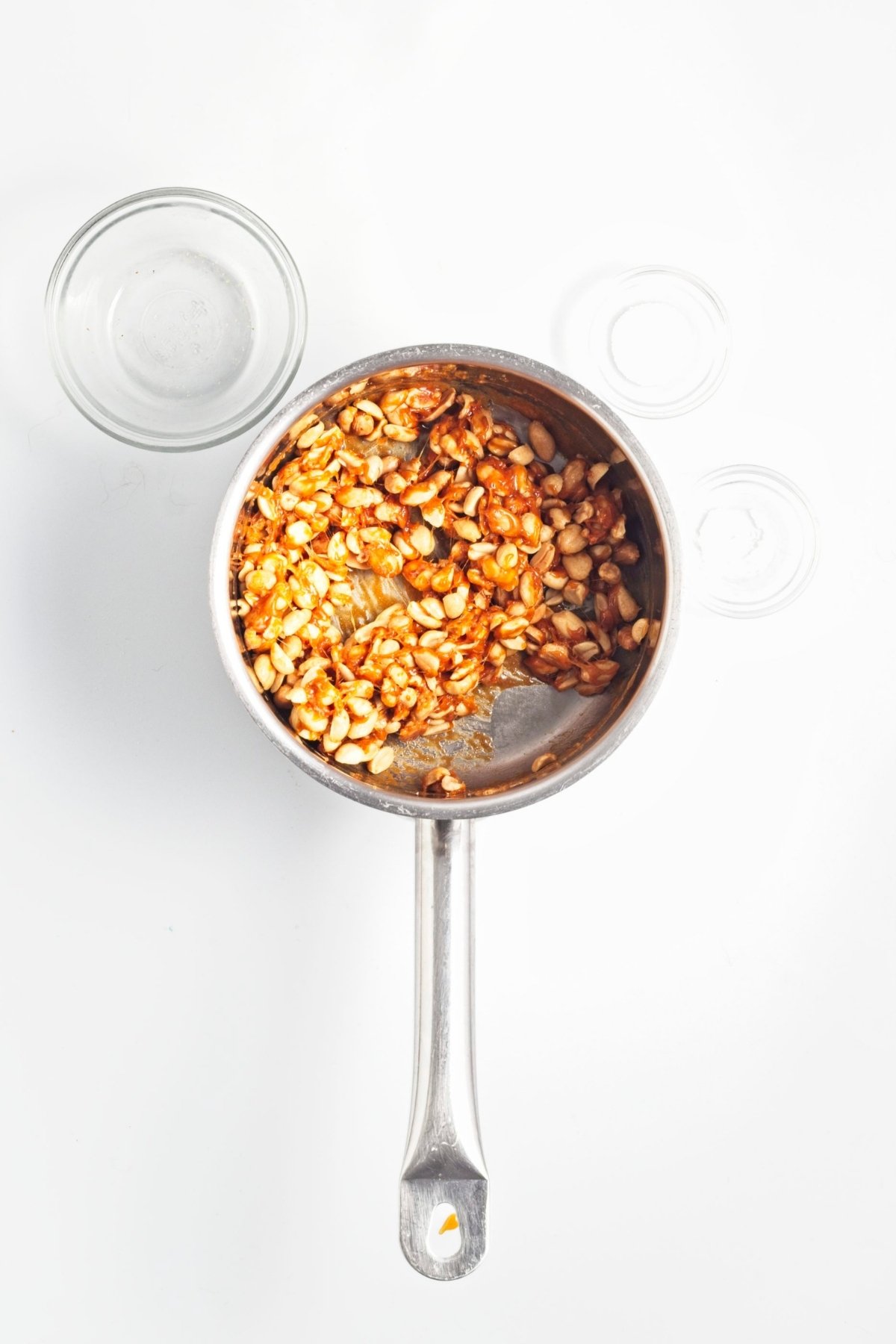 Caramel-coated peanuts cooling in a saucepan for brittle.