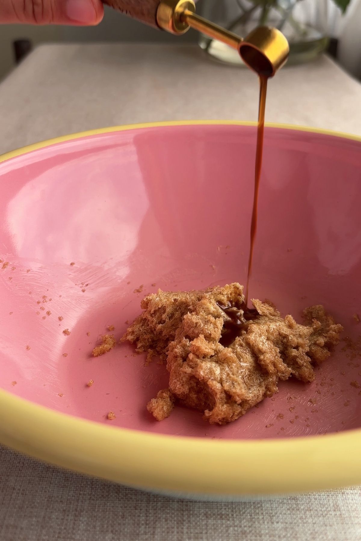 Vanilla extract being poured into creamed sugar and butter mixture.