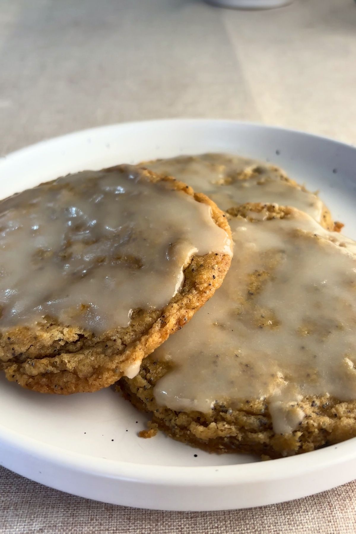 Three glazed cookies on a white plate.