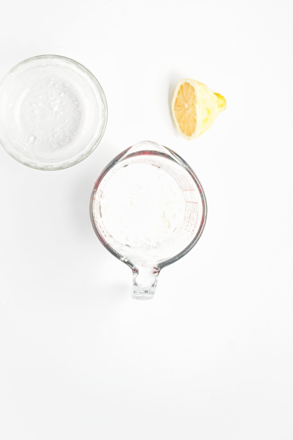 Measuring jug of powdered sugar and small bowl of lemon juice for glaze.