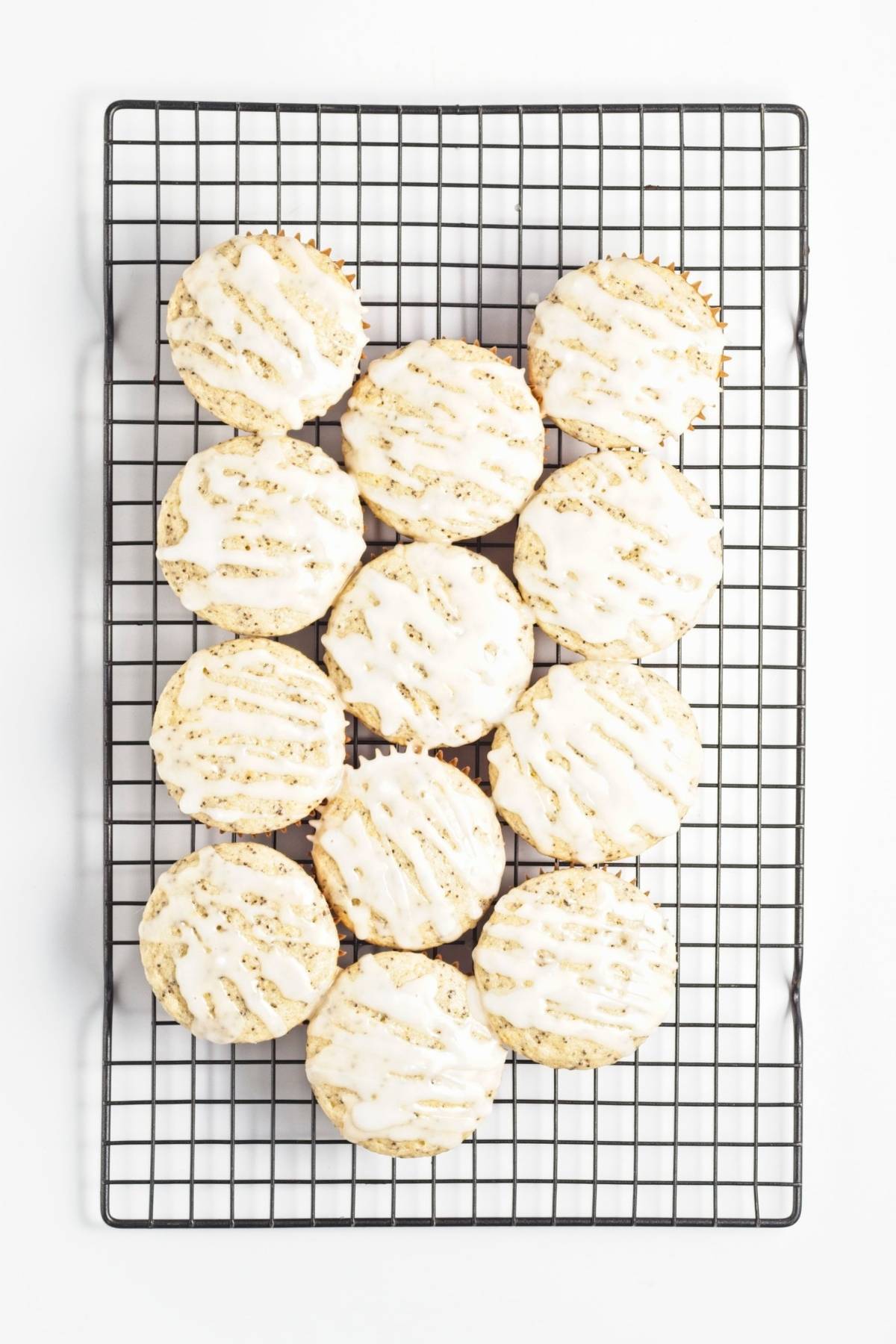 Glazed muffins on a wire rack, drizzle set on top.