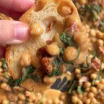 Slice of bread topped with creamy chickpeas and spinach.
