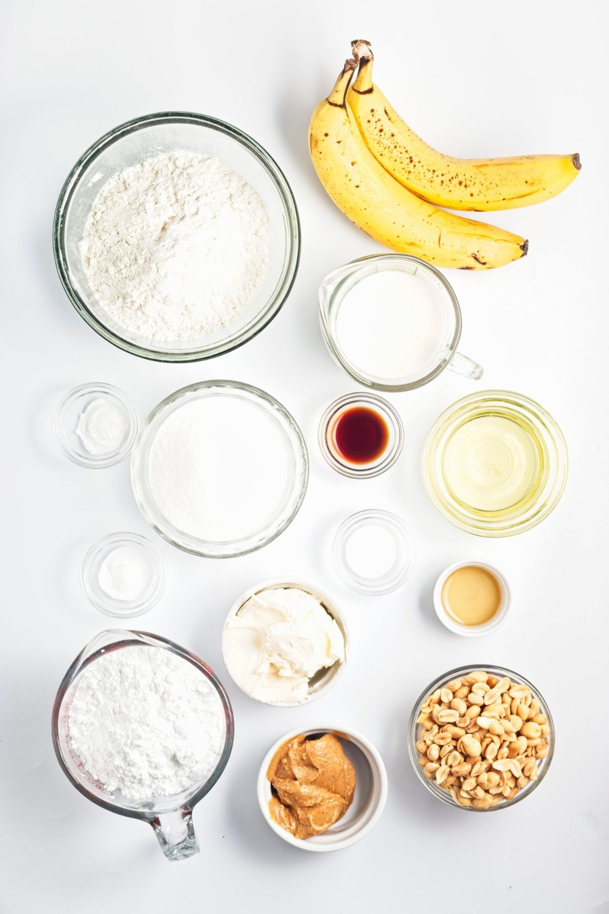 Measured ingredients for cupcakes, frosting, and brittle arranged on a white surface.