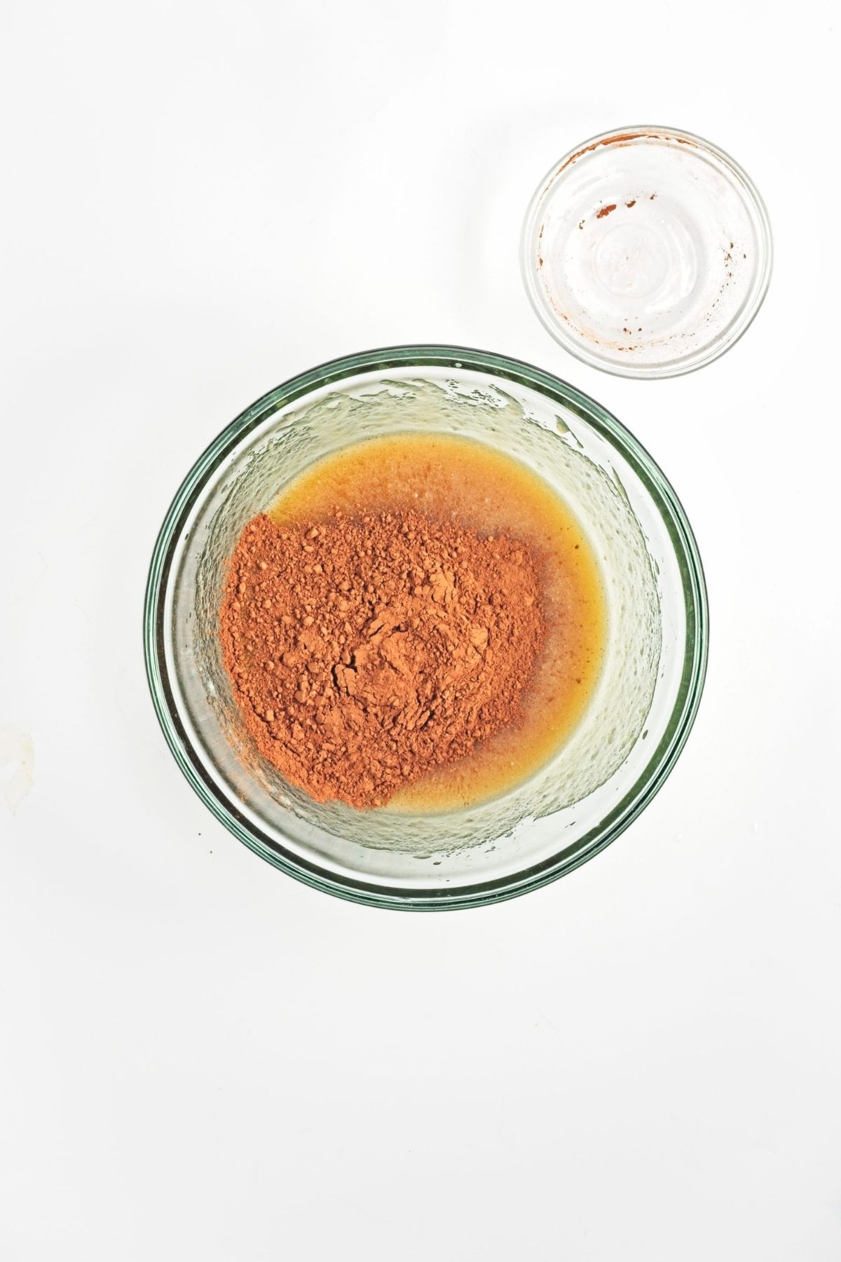 Bowl with cocoa powder added on top of mixed wet ingredients, ready to be stirred together.