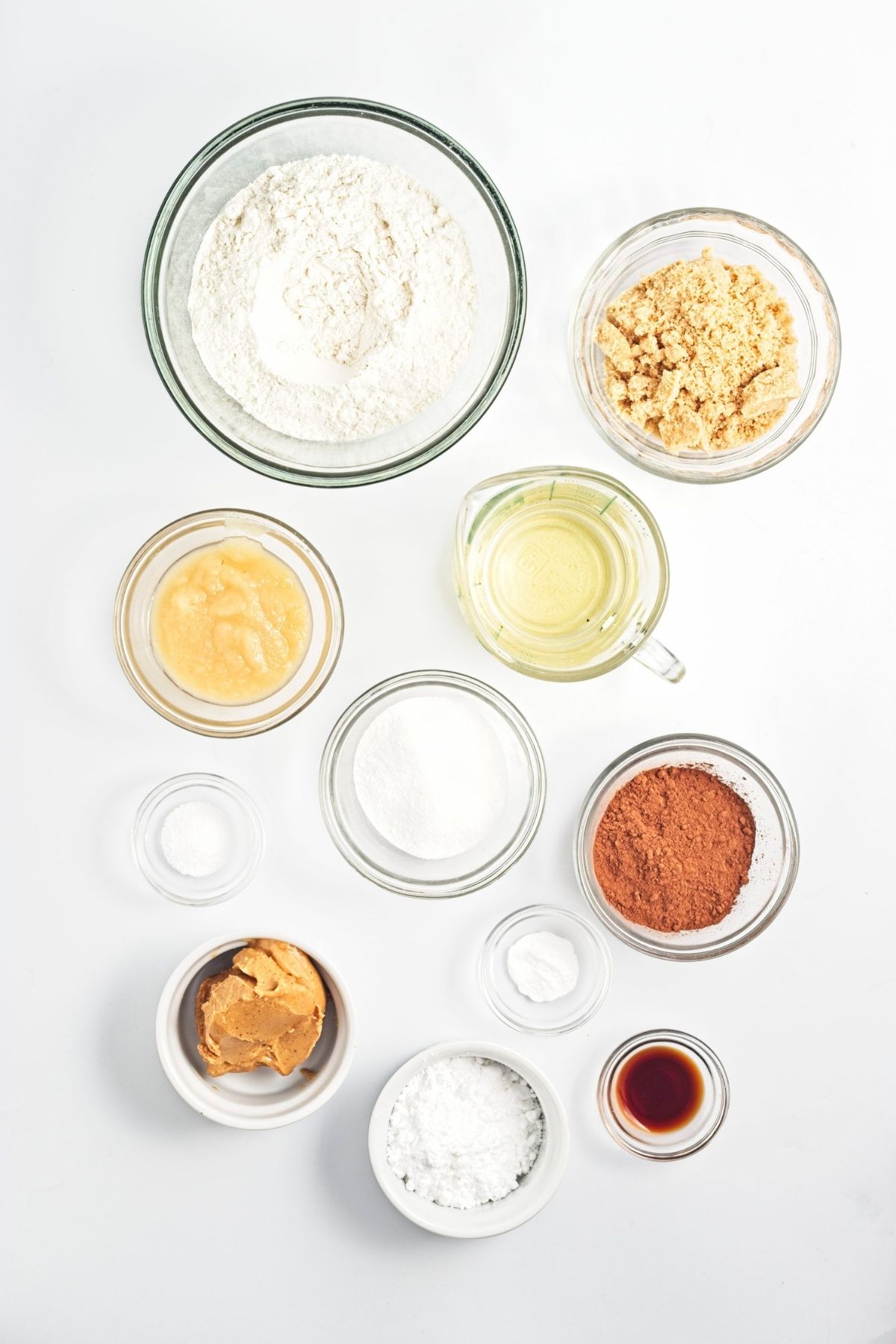 Overhead view of measured baking ingredients in small glass bowls.