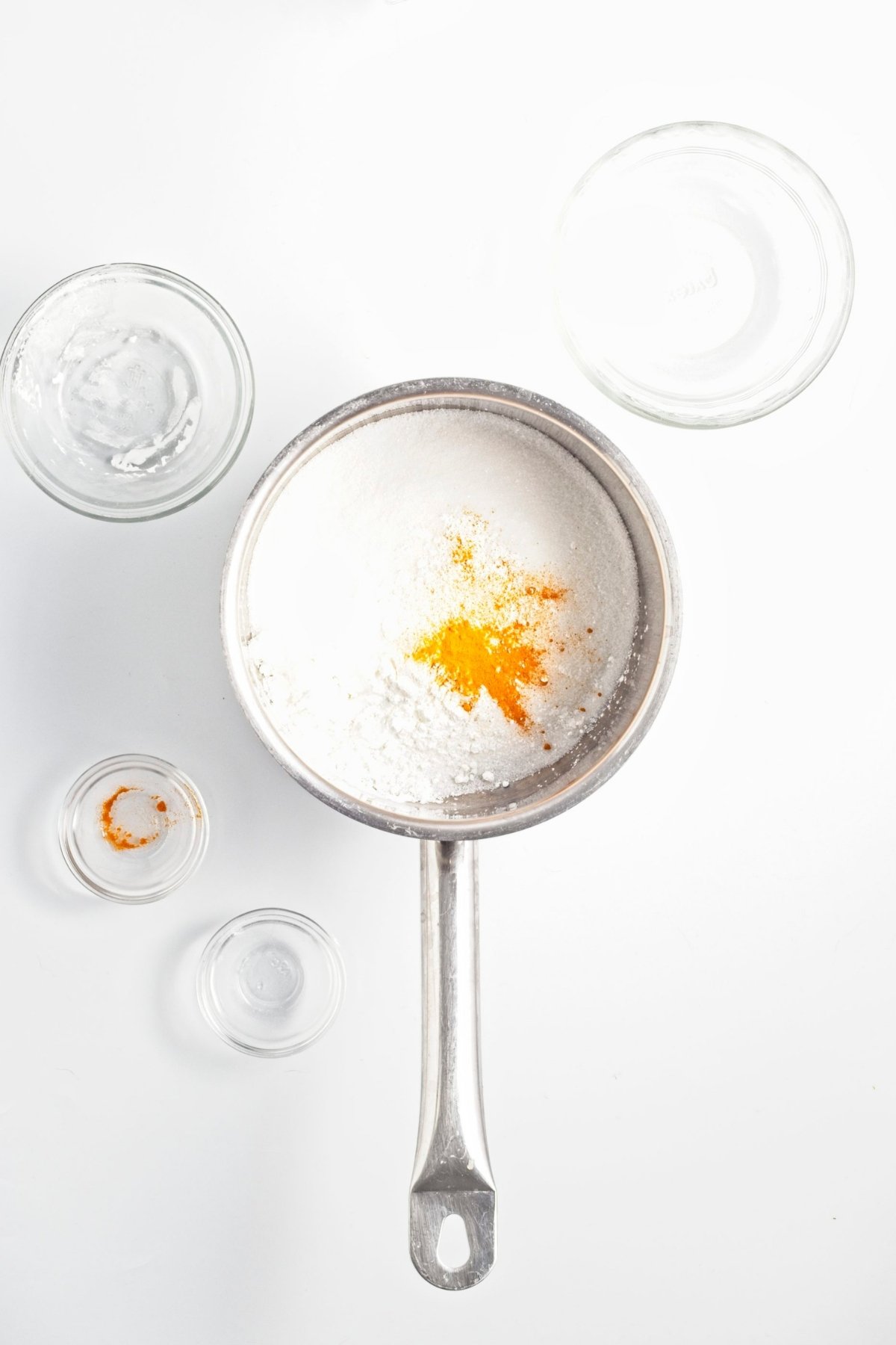 Saucepan with sugar, cornstarch, salt, and turmeric powder.