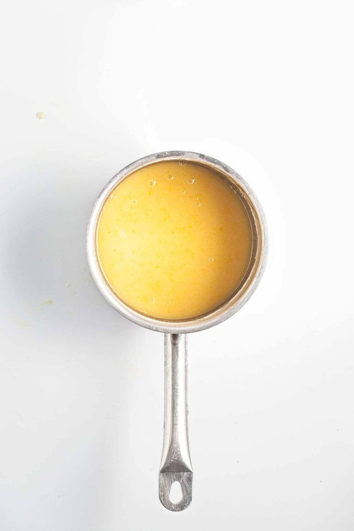 Saucepan with lemon mixture turning bright yellow.