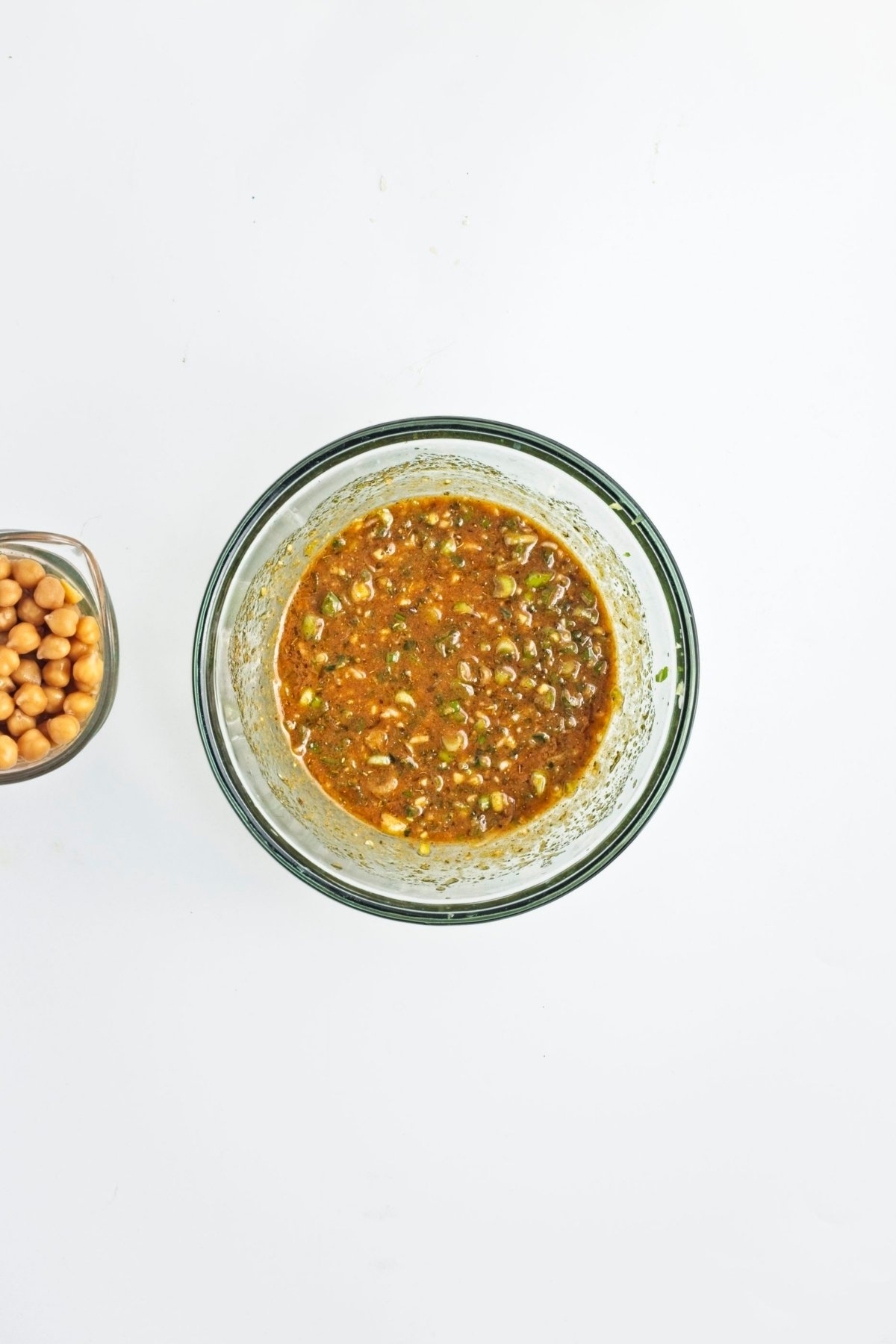 Dressing ingredients in a bowl with chopped green onions, spices, and mustard.
