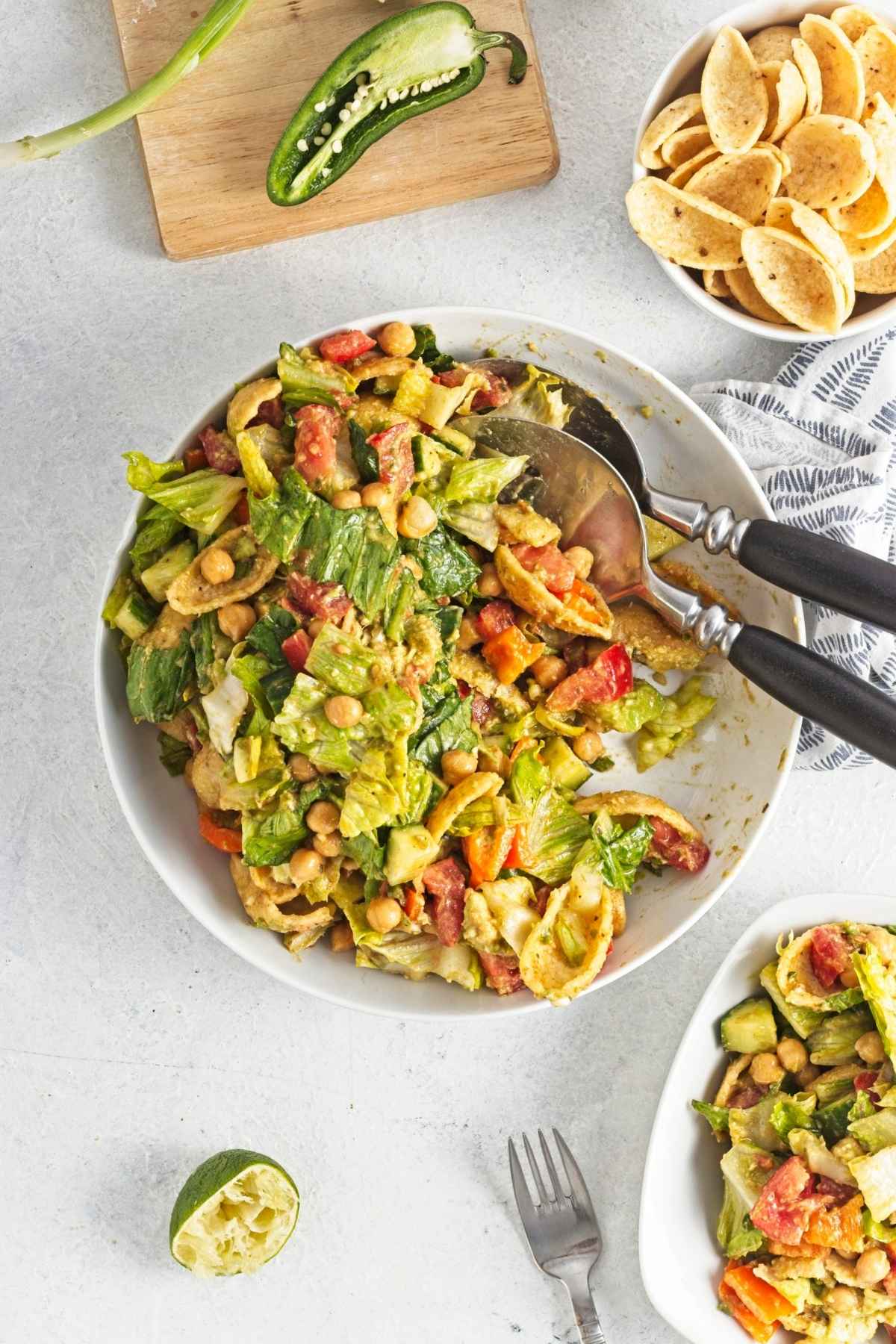 Close-up of mixed salad with lettuce, chickpeas, cucumber, tomatoes, and bell pepper.