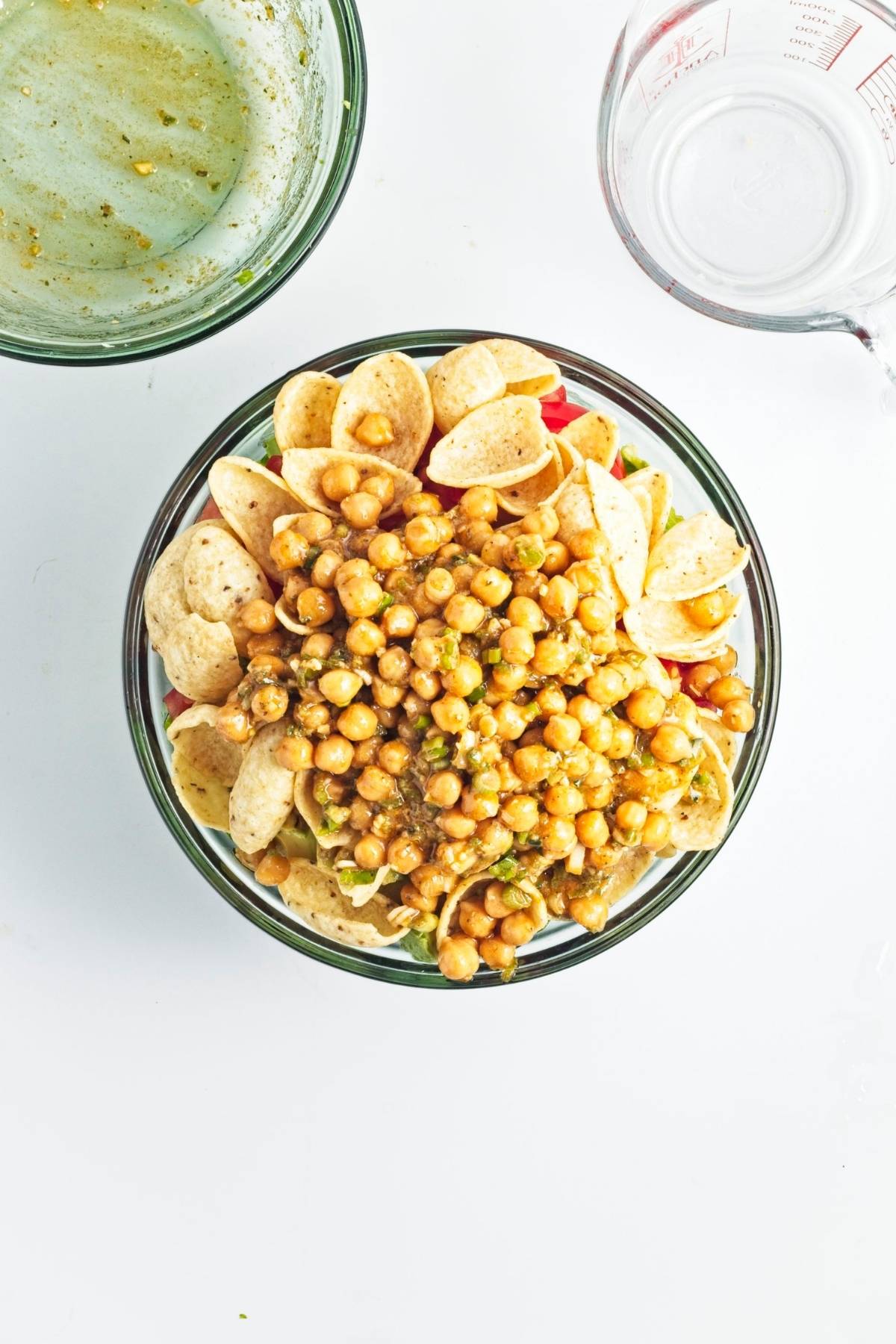 Salad bowl with tortilla chips and marinated chickpeas on top.