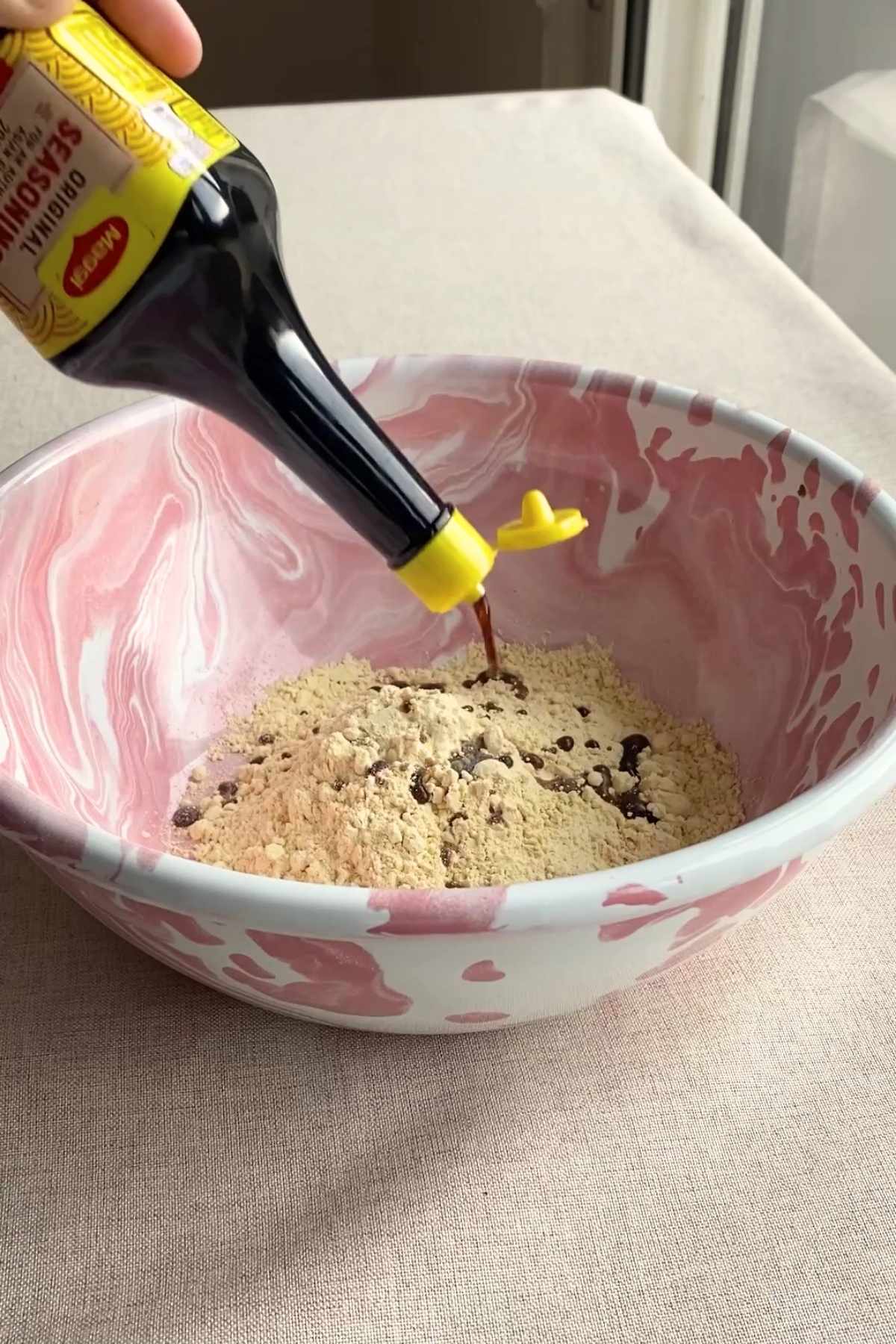 Seasoning being poured into a bowl of dry mix.