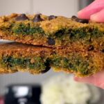 Cookie split in half showing a soft green center with melty chocolate chips.