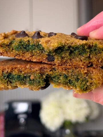 Cookie split in half showing a soft green center with melty chocolate chips.