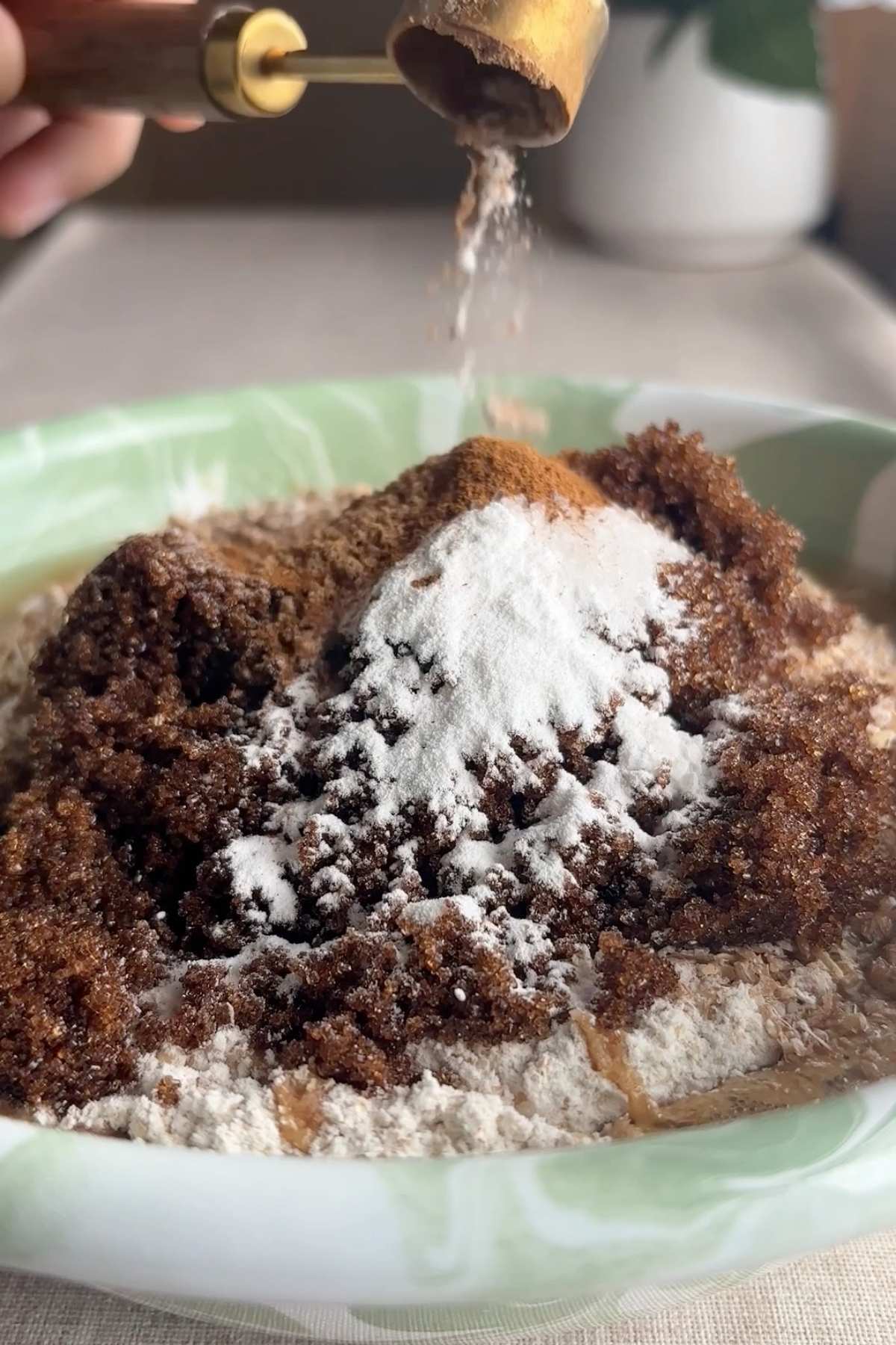 Brown sugar, flour, and spices being added to a bowl.
