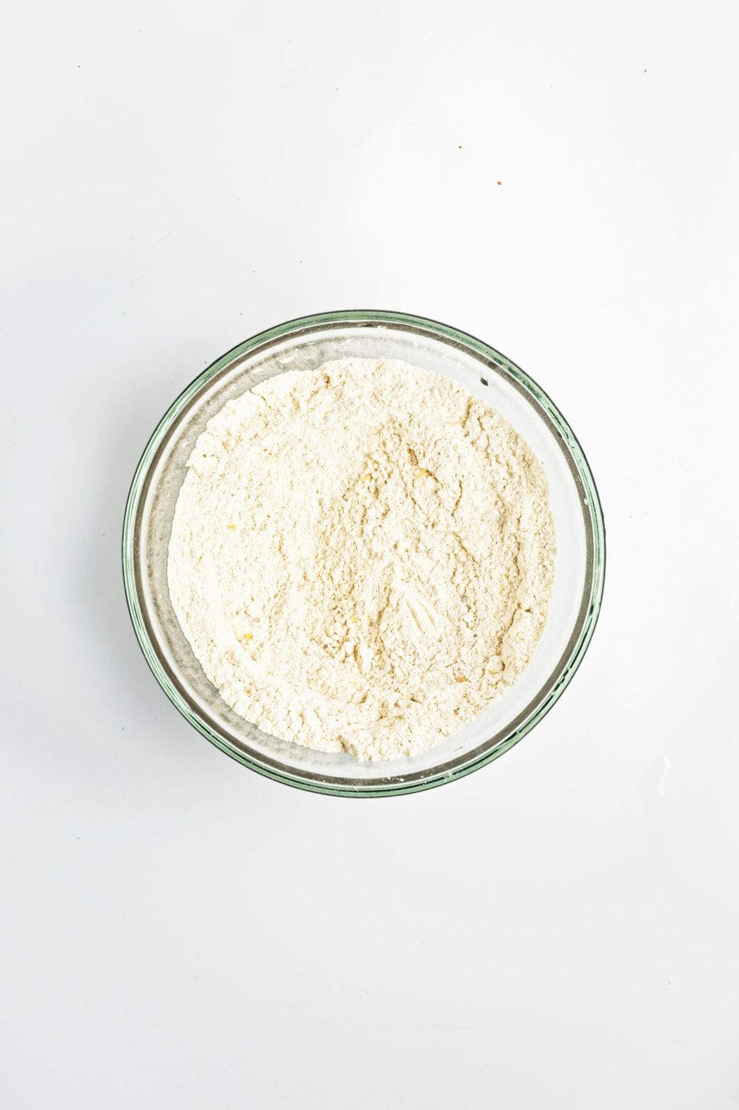 Corn flour and all-purpose flour mixed together in a glass bowl.