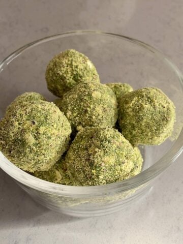 A bowl filled with several green-coated balls.