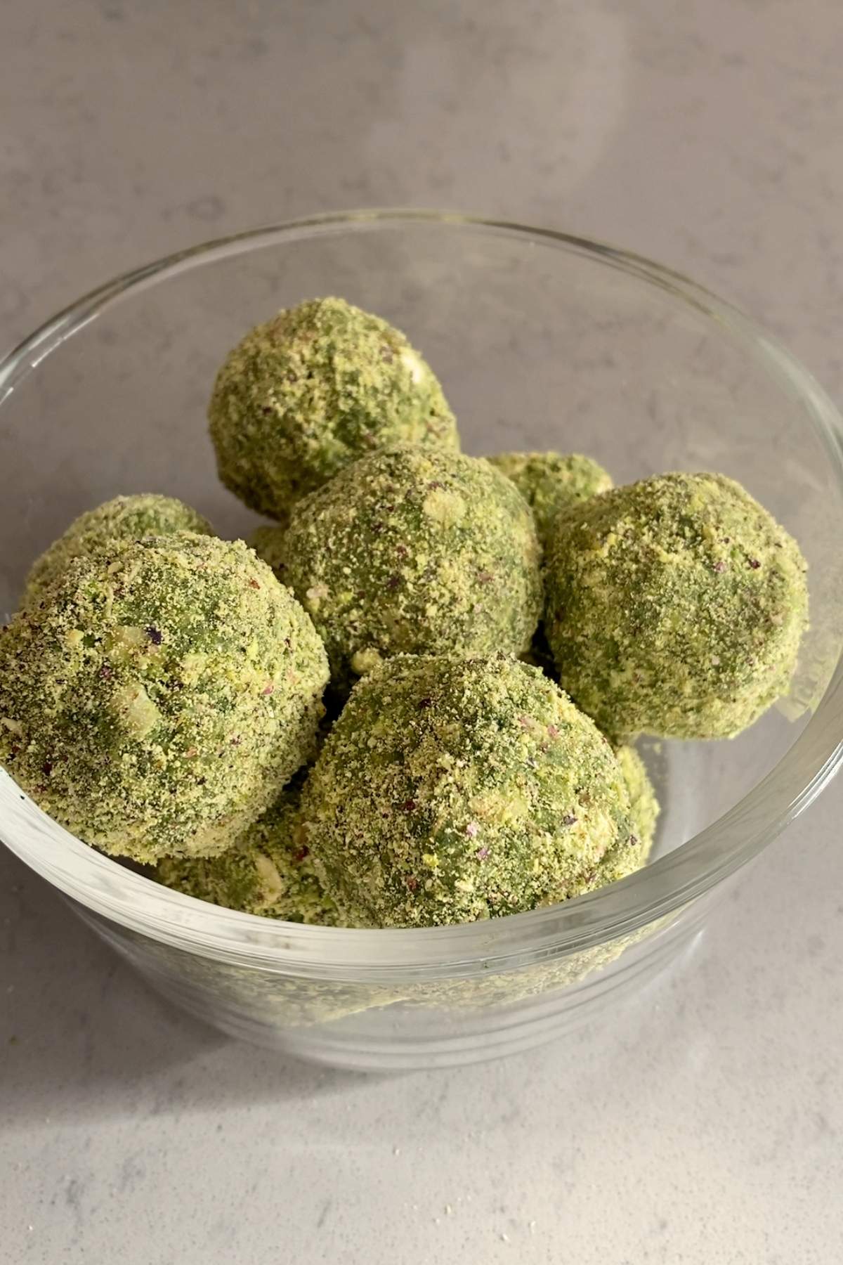 A bowl filled with several green-coated balls.