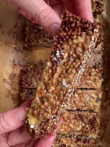 Close-up of a chocolate quinoa bar showing crunchy layers and peanut butter topping.