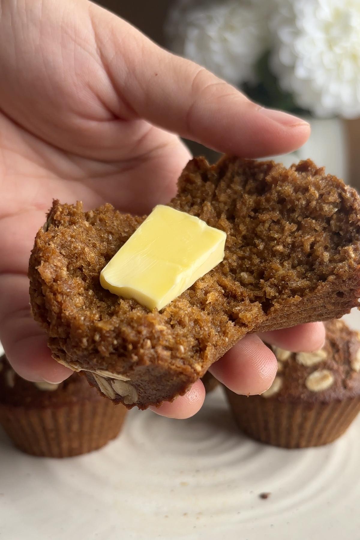 Warm muffin half topped with a melting square of butter.