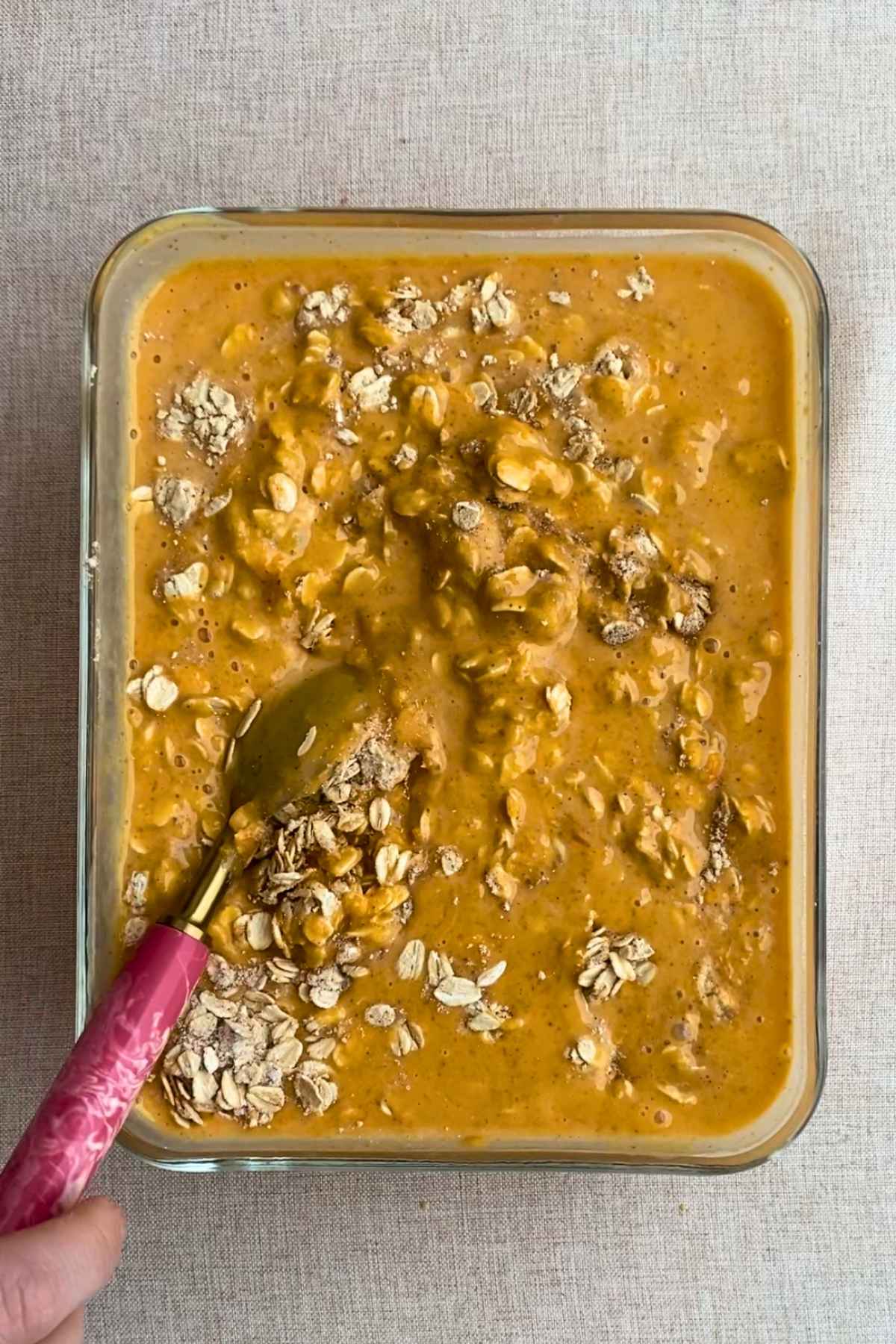 Pumpkin, nut butter, and milk being whisked together in a bowl.